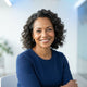 A diverse woman smiling in a bright, modern studio portrait representing a satisfied customer.